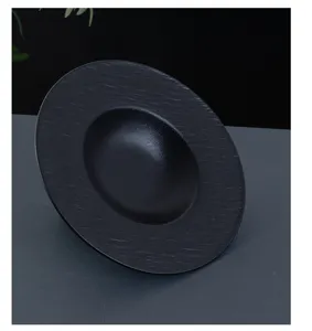 Black ceramic sombrero plate detail shot, vintage pasta bowl for fine dining tabletop setup.