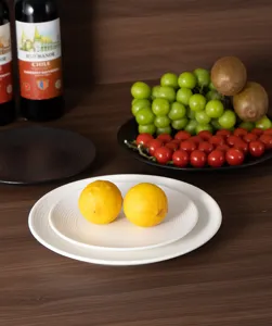 Detailed close-up shot of white ceramic ribbed plate on wooden table with fresh yellow lemons.