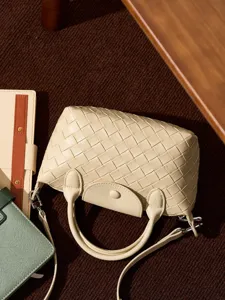Chic woven leather crossbody bag for women, stylish beige top handle dumpling handbag with shoulder strap.