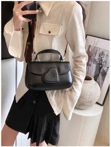 Nahaufnahme der stilvollen schwarzen PU-Ledertasche mit Herzverschluss und Schultergurt.