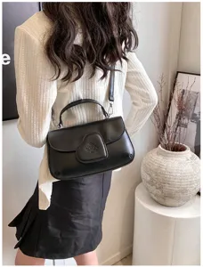 Schicke schwarze PU-Ledertasche mit Herz-Verschluss Detail für modische Alltagslooks.