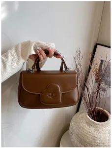 Detailaufnahme der braunen PU Leder Handtasche mit stilvollem Herzklappendesign und Beschlägen.