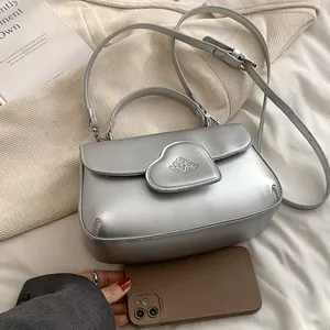 Silberne PU Leder Umhängetasche für Damen, stilvolle Handtasche mit Herzklappe und Tragegriff.