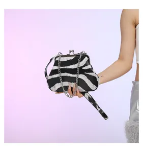 Detailansicht der modischen Handtasche mit schwarz-weißem Zebramuster und Metallkette.
