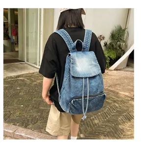 Retro denim backpack detail showing canvas material, drawstring closure and front zip pocket.