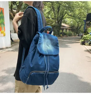 Detailed view of the retro denim backpack showing front pocket, zipper, and texture.