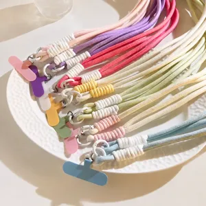 Dettaglio cinturino per telefono intrecciato colorato, lunga tracolla per cover e borse.