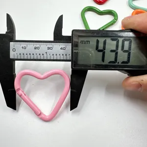 Measurement detail of colorful alloy heart carabiner clip, showing size with digital caliper.