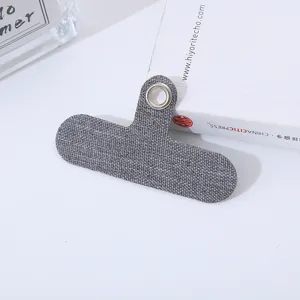 Primer plano detallado de una lengüeta de tela gris para cordón de teléfono con ojal metálico.