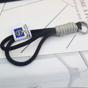 Black woven nylon keychain with grey accent wrapping and metal ring detail close up shot