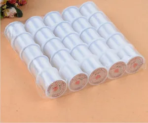 Detailed close-up of transparent beading thread spools, neat arrangement, DIY craft supply.