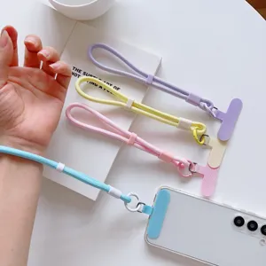 Detalle de la correa de muñeca para teléfono pastel con deslizador ajustable y cordón.