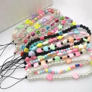 Lanière de téléphone colorée en perles avec des pendentifs smiley mignons pour femmes.