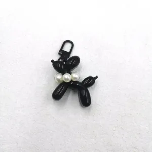 Black acrylic balloon dog keychain pendant with white pearls charm for bags and phone cases.