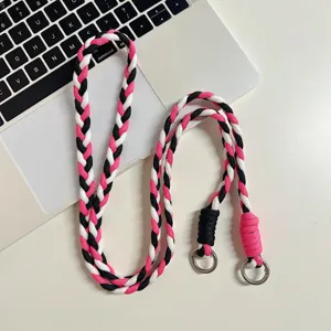 Détail de lanière tressée pour téléphone, sangle rose noire blanche avec anneaux.