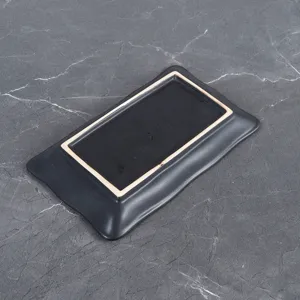Assiette à sushi rectangulaire noire en céramique avec bord ondulé, vaisselle moderne.