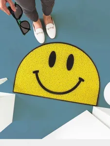Detalle de felpudo semicircular cara feliz amarilla, alfombra antideslizante entrada.
