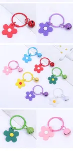 Close-up details of colorful PVC flower bell keychains, perfect DIY bag pendants and phone accessories.
