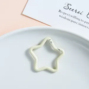 Close-up detail of cream white star shaped metal spring buckle keychain connector accessory.
