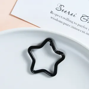 Close-up of black star-shaped metal spring snap hook, keychain jewelry accessory detail.