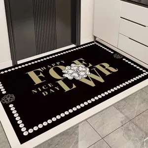 Black PVC entryway door mat with camellia flower pattern and gold typography for home decor.
