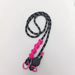 Detail shot of the black white woven phone lanyard with pink braided section and adjustment buckle.