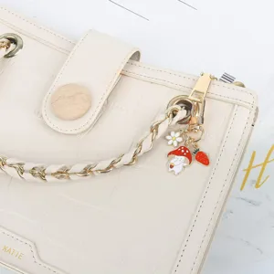 White crocodile pattern handbag with cute mushroom rabbit charm and braided chain strap details.