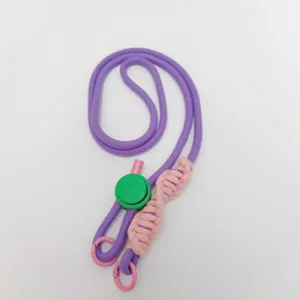 Close up of purple crossbody phone lanyard with pink braided details and green adjustment buckle.