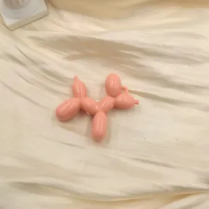 Pink acrylic balloon dog charm close-up, cute keychain pendant and phone case accessory.