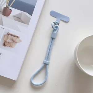 Primer plano de la correa de muñeca para teléfono azul claro con lengüeta y hebilla ajustable.