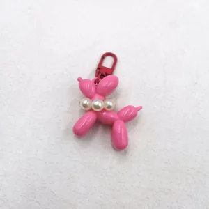 Pink acrylic balloon dog keychain charm with pearl necklace detail view for bags and keys.