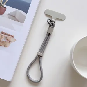 Correa de muñeca corta gris para teléfono con lengüeta y hebilla ajustable para uso seguro.