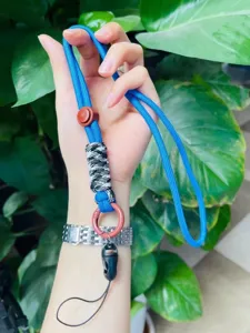 Vue rapprochée de la lanière de téléphone tressée bleue et noire avec boucle réglable.