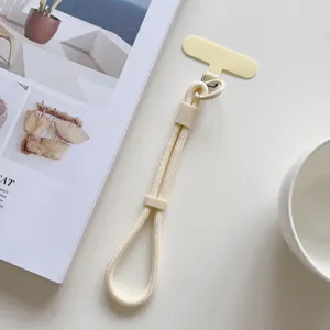 Correa de muñeca corta para teléfono móvil beige con almohadilla y hebilla ajustable.