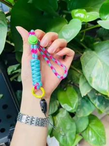 Gros plan detaillee de la dragonne de telephone tresses bicolore avec boucle reglable.