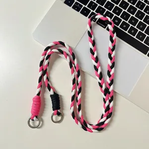 Lanière de téléphone tressée en rose, noir et blanc avec des anneaux métalliques anti-perte.