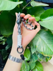 Dragonne de téléphone tressée noire et blanche réglable avec porte-clés et fermoir solide.