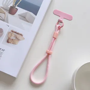Detalle de correa rosa para teléfono con deslizador ajustable y cuerda tejida resistente.
