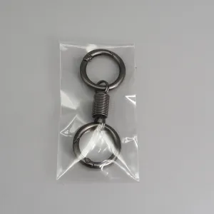 Dettaglio del portachiavi a molla in metallo, design creativo con doppio anello e struttura.