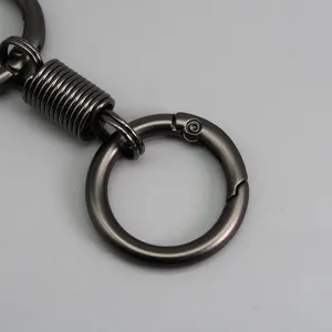 Dettaglio ferramenta per portachiavi in metallo con chiusura a molla scura e connettore resistente.