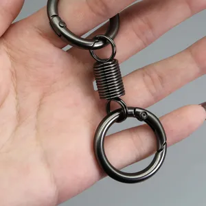 Dettaglio in primo piano del portachiavi a molla in metallo con anello e robusta chiusura.