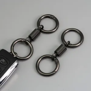 Dettaglio portachiavi a molla in metallo, finitura gunmetal, con doppio anello.