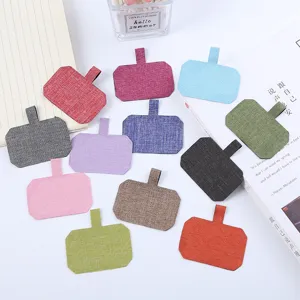 Linguette di fissaggio in tessuto multicolore per cover di telefono e accessori vari.