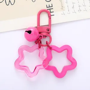 Pink acrylic star keychain detail shot with metal hook and cute bell pendant accessory.