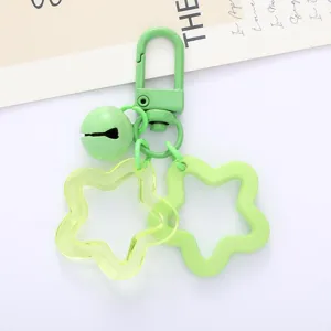 Green pentagram acrylic keychain charm with bell and metal clasp, detailed close-up shot.