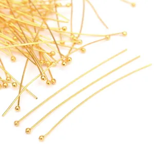 Close-up detail of gold-toned jewelry ball pins for DIY crafting and earring making.