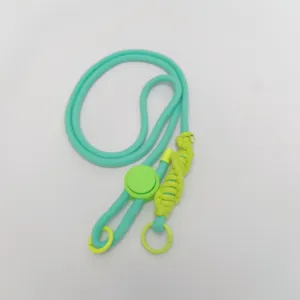 Details of the mint green crossbody phone lanyard with neon yellow buckle and braided rope.