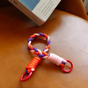 Detailansicht des bunten geflochtenen Handyarmbands mit leuchtend orangen, violetten Kordeln.