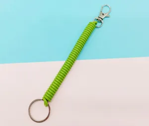 Vue détaillée du porte-clés à spirale en plastique vert vif avec mousqueton métal.
