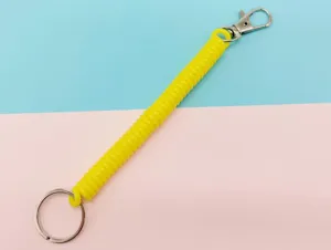 Porte-clés spirale en plastique jaune avec anneau métallique et fermoir détail.